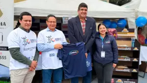 Representantes de Exibal durante evento de inocuidad alimentaria entregando camiseta institucional en feria agroindustrial