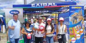 Equipo de Exibal en el stand de la feria agropecuaria de Pastaza junto al inflable publicitario