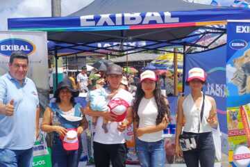 Equipo de Exibal en el stand de la feria agropecuaria de Pastaza junto al inflable publicitario